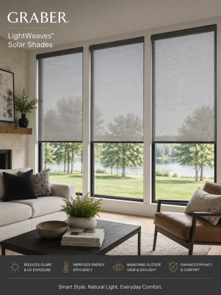 A modern living room with large windows fitted with stylish Graber Lightweaves Solar Shades, overlooking a green landscape and lake. Text highlights benefits: reduces glare, improves energy efficiency, maintains outdoor view, and enhances privacy.