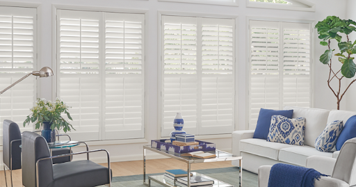 Bright white shutters in windows in a modern living room with blue accents
