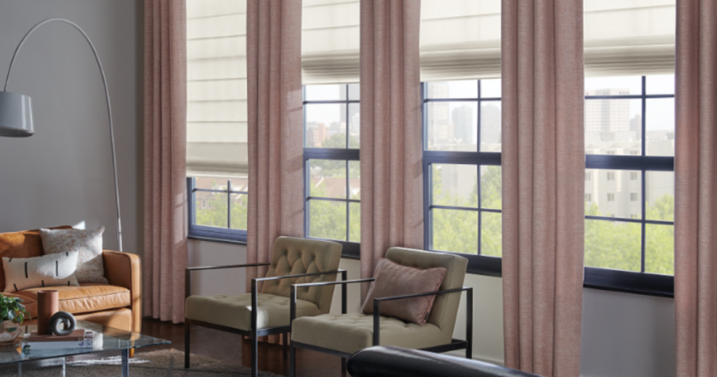 Layered window treatment including Roman shades and floor-length drapes in a modern living room